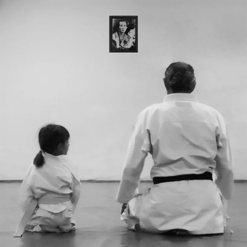 El maestro Gerardo medita en seiza junto a una joven alumna que le mira